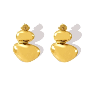 Gros plan de boucles d'oreilles dorées géométriques irrégulières au fini poli miroir
