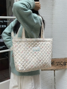 Detail of quilted cotton tote bag featuring colorful floral and butterfly patterns