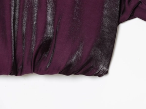 Detailaufnahme von dunkelviolettem Metallic-Stoff mit elastischem Saum und Glitzereffekt