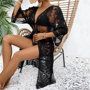 Detail of black lace crochet beach cover-up featuring intricate floral cutout patterns