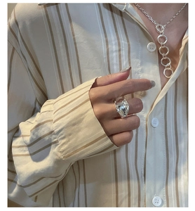 Polished silver saddle ring and tiered chain necklace worn with a striped shirt