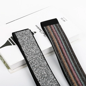 Detail of black elastic waist belts with silver and colorful rhinestones in a macro shot