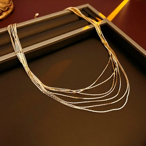 Detail of multi-layer gold plated snake chain necklace displayed on a jewelry tray