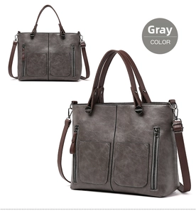 Detail view of large grey PU leather tote bag with functional pockets and brown handles