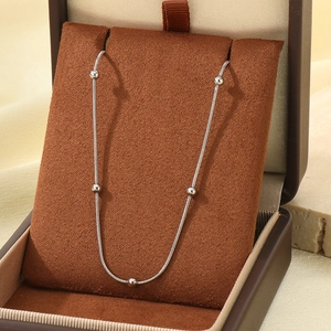 Collier chaîne serpent argentée avec cinq perles présenté dans un écrin à bijoux