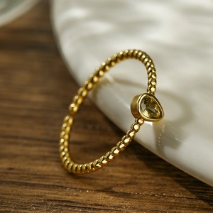 Macro shot of 18K gold plated ring with teardrop yellow zircon and beaded band detail