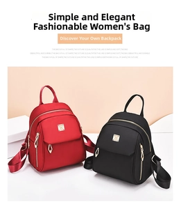 Detail of red and black mini nylon backpacks with gold zippers and wing metal hardware