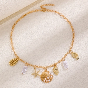 Details einer goldenen Halskette mit Barockperlen, Muscheln und Seestern-Anhängern