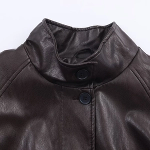 Close-up of high stand collar and button details on dark brown faux leather jacket