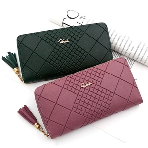 Top view of two long zip wallets in green and pink with geometric embossed patterns