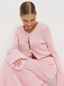 Detail view of pink knit cardigan with elegant lace-up bow and flare sleeves
