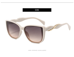 Detail of fashion oversized sunglasses with beige frame and gold twist patterned temples