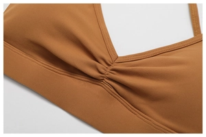 Macro detail of V-neck sports bra with ruched center and reinforced stitching in caramel