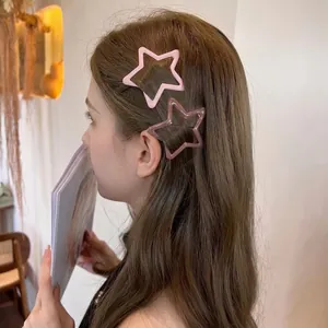 Pink star-shaped hair clips for women shown on a model in a minimalist indoor setting