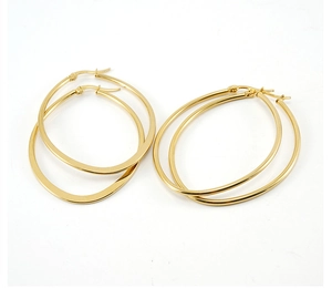 Detailed view of polished 18K gold egg-shaped hoop earrings with secure hinge closures