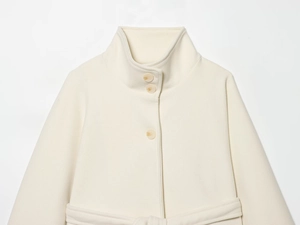 Detail of cream white wool cape coat featuring a stand collar and button-up closure