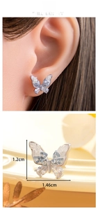 Détail de boucle d'oreille papillon argentée avec cristaux bleus et fermoir à vis