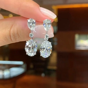 Macro shot of large drop-shaped silver crystal earrings with multi-stone tiered design