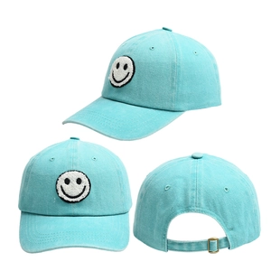 Detail of mint green cotton baseball cap showing smile embroidery and metal buckle