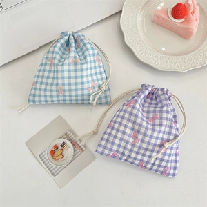 Flat lay of blue and purple checkered drawstring storage pouches with pink bow prints