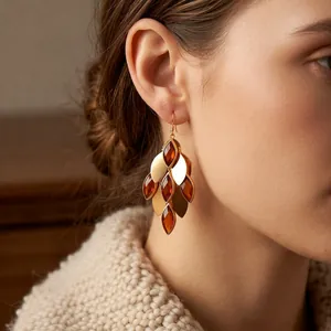 Vintage 18K gold plated leaf drop earrings with amber glass petals on a knit sweater