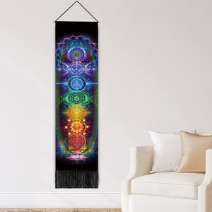 Bohemian Seven Chakra tapestry with rainbow colors and black tassels on white wall