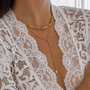 Close-up of dual-layer golden star choker and Y-shaped titanium steel necklace on a model