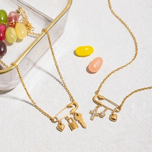 Golden stainless steel paperclip necklaces with heart, lock and cross charms on stone