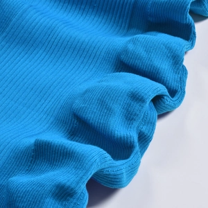 Détail du tissu en maille côtelée bleu roi montrant la texture douce et les rayures verticales