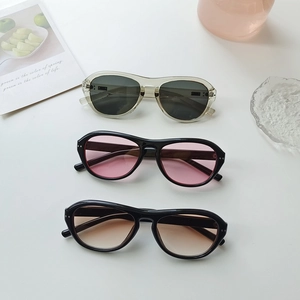 Retro oversized sunglasses in grey, pink, and brown lenses shown in a top-down view