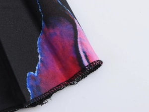 Vue détaillée de l'imprimé floral coloré et de la couture surjet sur le tissu noir
