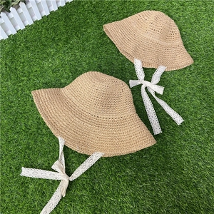 Detail of hand-woven straw hats for mother and child with delicate white lace ribbons