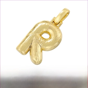 Macro detail of 18K gold plated brass bubble letter R pendant with brushed texture finish