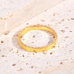 Macro detail of 18K gold plated titanium ring with irregular hammered texture on stone