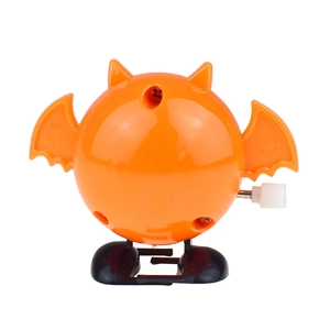 Close-up of a wind-up orange bat toy with mechanical knob and walking feet for Halloween