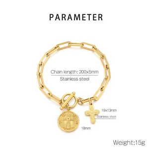 Macro detail of gold stainless steel toggle clasp and cross charms on link bracelet