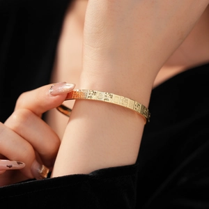 Detail of gold mahjong bracelet featuring embossed character and premium metal texture