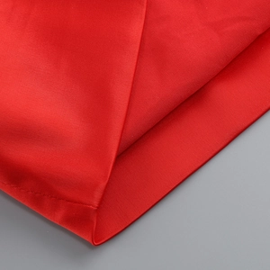 Close-up of red tight dress fabric texture and precision stitching on the hemline
