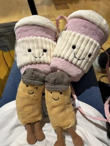 Close-up of plush pink coffee cup and brown character toys with cute embroidery