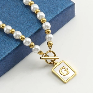 OT buckle pearl necklace with 18K gold letter G shell pendant on blue texture gift box