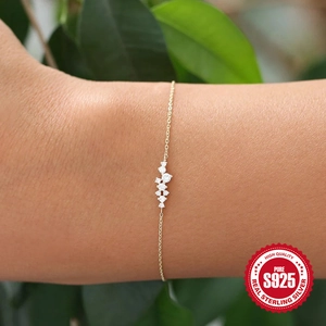 Minimalist S925 sterling silver gold plated bracelet with five cubic zirconia stones on wrist