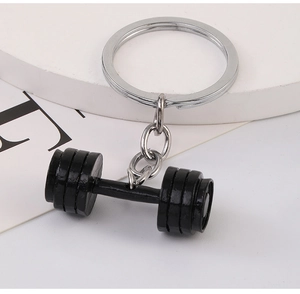 Detail of creative black dumbbell keychain with silver metal ring for fitness enthusiasts