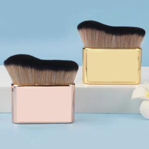 Close-up of wavy fiber bristles and metallic flat handle of a large foundation brush