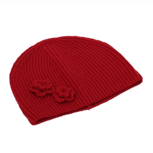 Detailed view of red knitted flower beanie with classic vertical ribbed texture
