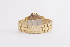 Detail of gold metal three-row link watch strap on a transparent acrylic display stand