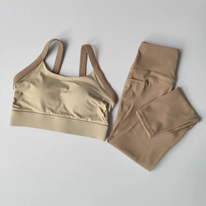 Detail of khaki high-waisted yoga leggings with side pockets and racerback sports bra