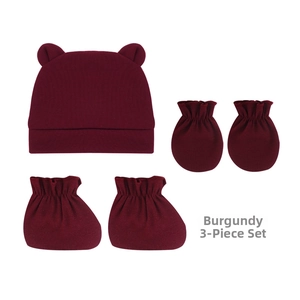Détail d'un ensemble en tricot bordeaux pour nouveau-né avec bonnet et moufles