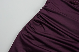 Detailed close-up of dark purple ruched fabric with delicate lace拼接 trimming accents