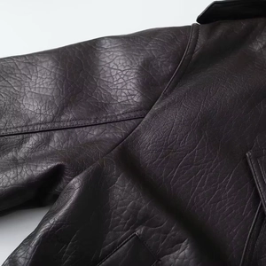 Detailed close-up showing reinforced stitching and premium leather grain on the brown jacket