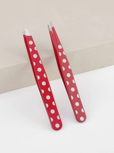 Detailed close-up of two red polka dot tweezers on a display stand for eyebrow shaping